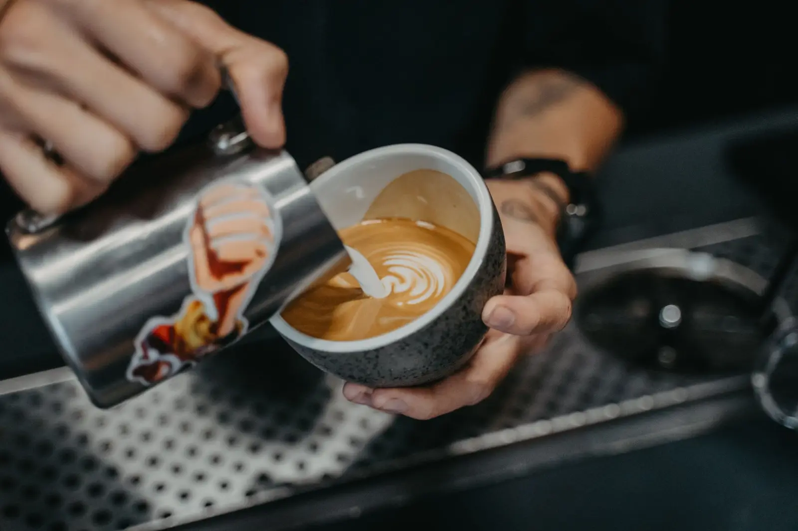 Barista pouring steamed milk into a latte